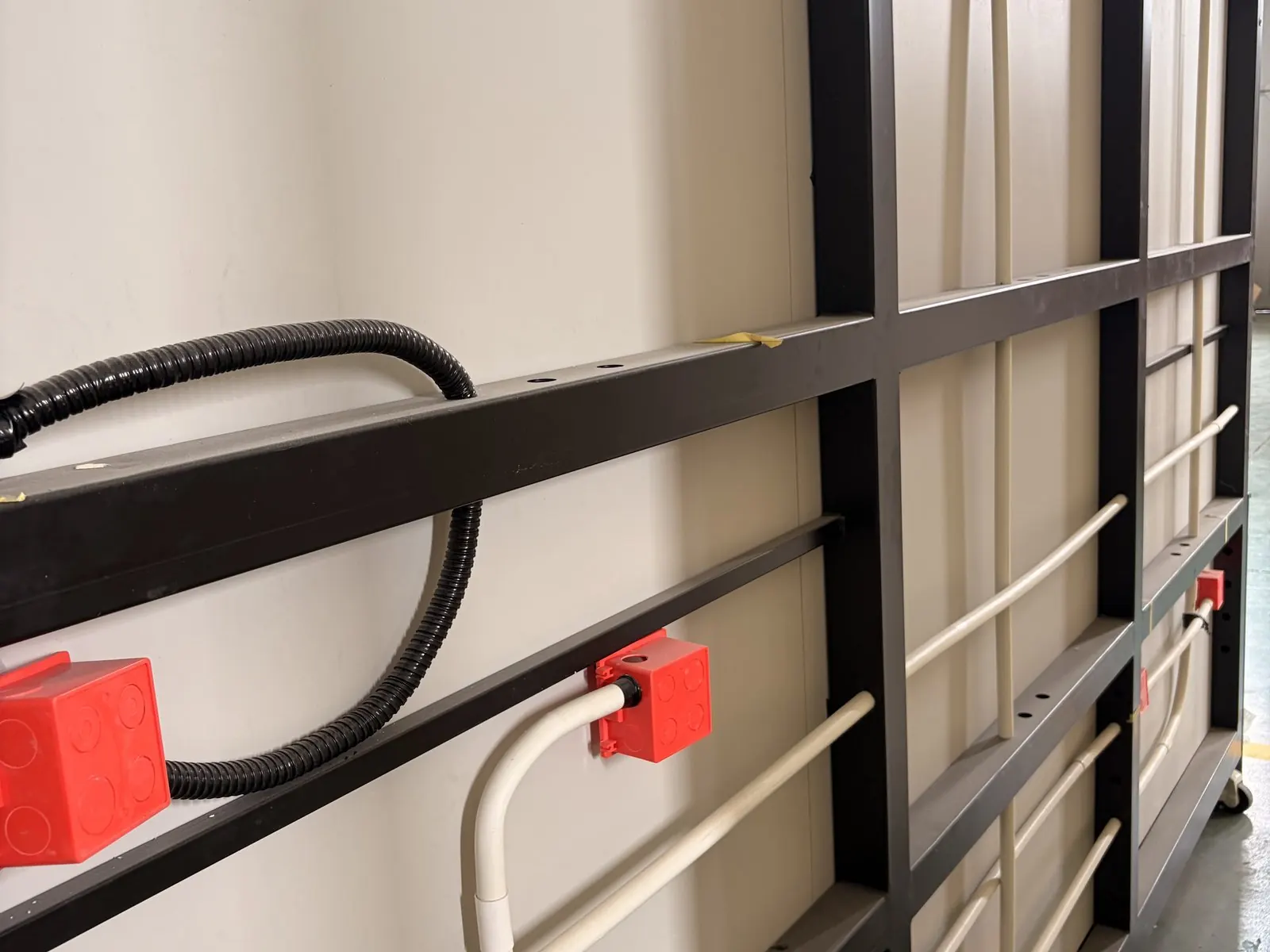 Gaine électrique et tubes de plomberie fixés sur l’ossature, dans la paroi